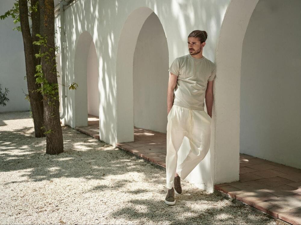 barbat imbracat in alb  sprijinit de perete